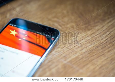 Smartphone On Wooden Background With 5G Network Sign 25 Per Cent Charge And China Flag On The Screen