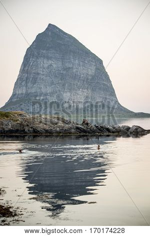 Norwegian landscape in the midnight sun with a mountain an still mirror sea