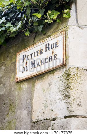 Old French street sign Petite Rue Du Marche or Market alley on an old limestone wall Ile de Re France
