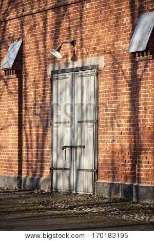 red brick wall and wooden door with vintage lamp