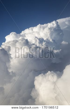 Close up on white fluffy storm clouds in front of blue sky