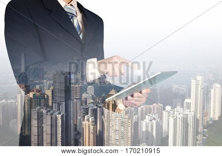 Double Exposure Of Businessman Using Tablet On Building Background..