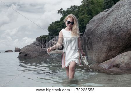 portrait of woman in white dress getting through the water