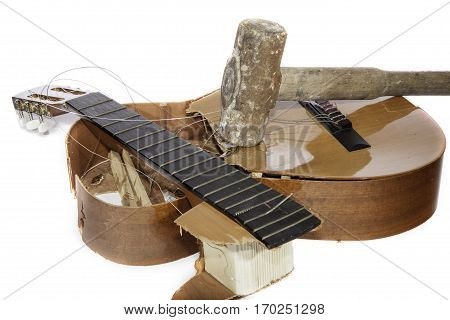 An acoustic guitar that has been smashed with a sledgehammer by its frustrated guitarist owner. No more music practice.