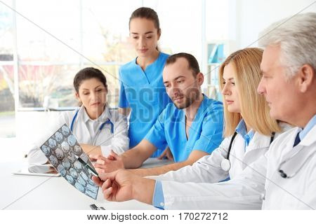 Team of doctors exploring roentgenogram at meeting