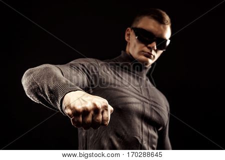 Right-hander punch. Close-up of a man's fist. Sunglasses. Studio shot.