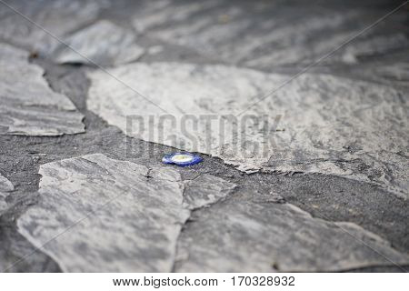 The evil eye bead inside the concrete of rocky road