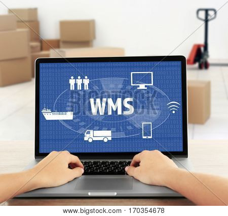 Warehouse management system concept. Woman working with laptop 