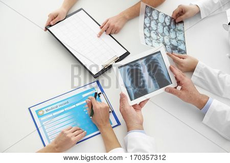 Team of doctors exploring lungs roentgenogram in clinic