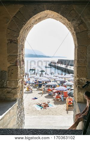 CEFALU,SICILY - JULY. 27. 2016: Unidentified people on sandy beach in Cefalu, Sicily, Italy at Sep 16, 2014. Cefalu is an attractive historic town and seaside resort.