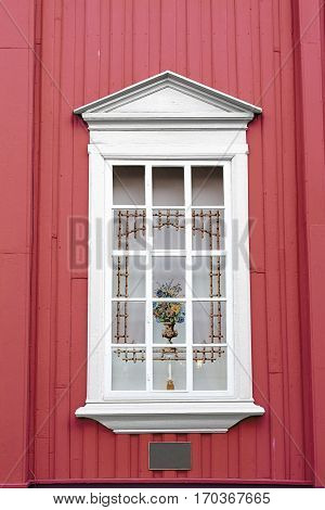 red wall white window curtain vase candle holder