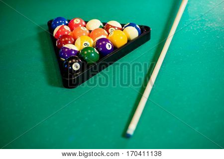 billiard table with billiard balls, cue and billiard triangle
