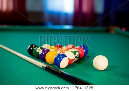 billiard table with billiard balls, cue and billiard triangle