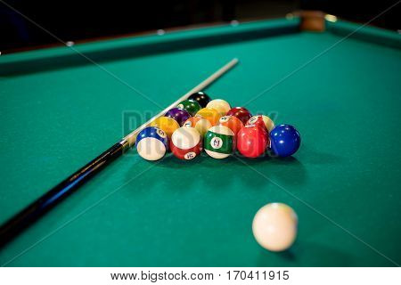 billiard table with billiard balls, cue and billiard triangle