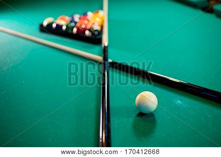 billiard table with billiard balls, cue and billiard triangle