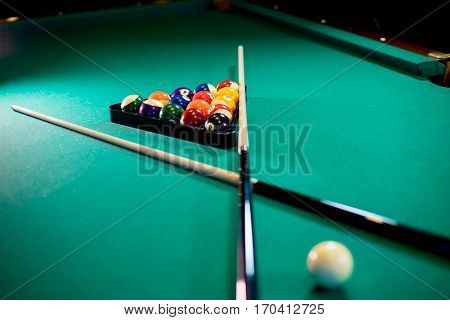 billiard table with billiard balls, cue and billiard triangle