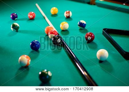 billiard table with billiard balls, cue and billiard triangle
