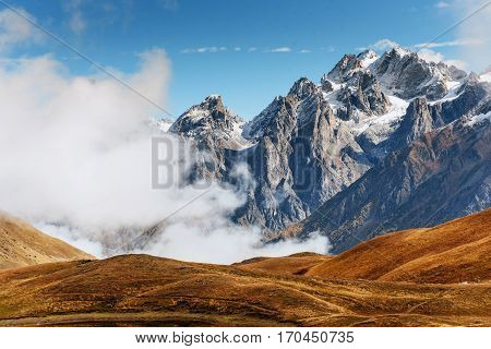 Snow-covered mountains in the mist. Autumn at Koruldi Lake. Europe, Georgia, Upper Svaneti, near mt. Ushba.