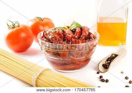 Italian spaghetti with ingredients for cooking pasta on a white background.