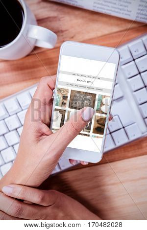 website frontpage against businesswoman using her smartphone on desk
