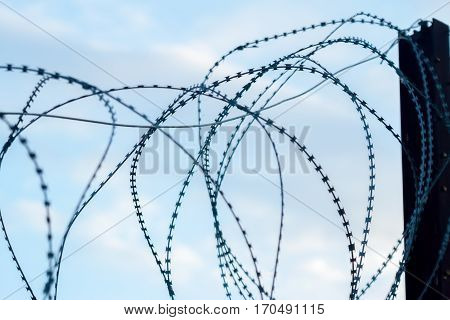 barbed wire on fence blue sky background