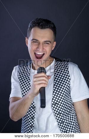Young Male Black-haired Rock Vocalist Performs Singing To Microphone