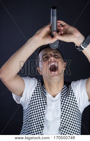 Young Male Black-haired Pop Vocalist Performs Singing To Microphone