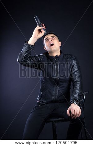 Young Male Black-haired Pop Singer Sings To Microphone
