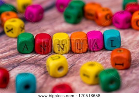 annual - word created with colored wooden cubes on desk.