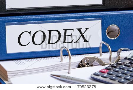 Codex - blue binder on desk in the office with pen and calculator