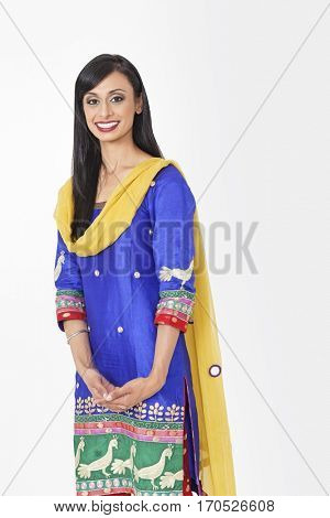 Portrait of beautiful Indian female traditional wear standing against gray background