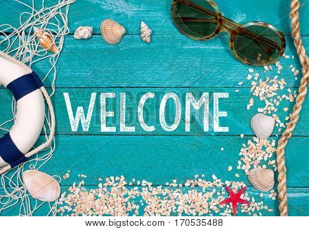 Welcome to the Beach - beach untensils on turquoise wooden background