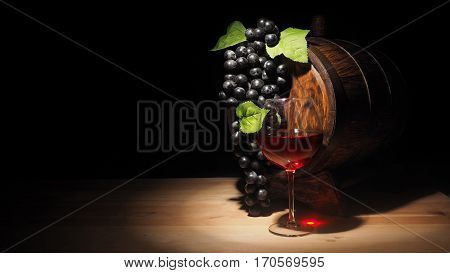 Glass Of Red Wine And Barrel On Wooden Table
