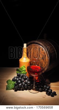 Glass Of Red Wine And Barrel On Wooden Table