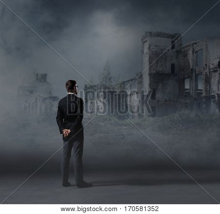 Businessman standing over apocalyptic background. Crisis, default, setback concept.