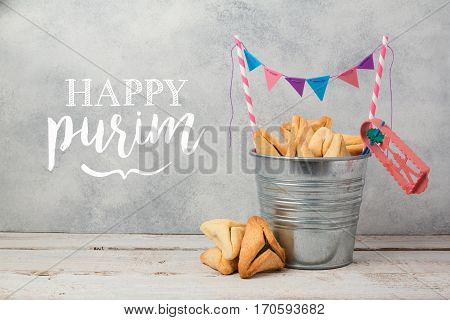 Purim holiday greeting card with hamantaschen cookies over rustic background
