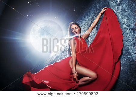 Stunning beautiful brunette posing against moonlight