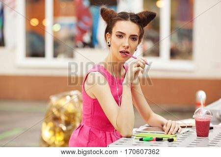 The girl in the pink dress with headphones composing