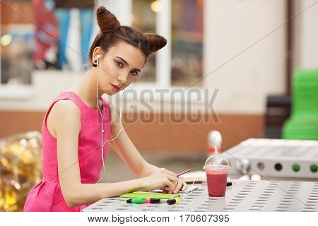 The girl in the pink dress with headphones composing