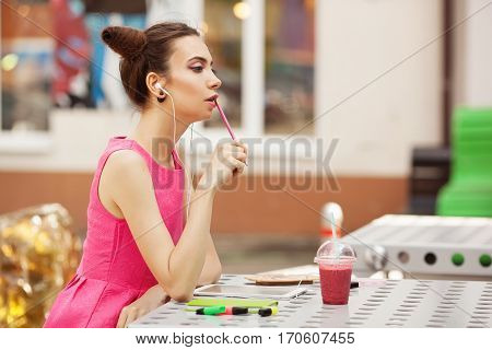 The girl in the pink dress with headphones composing