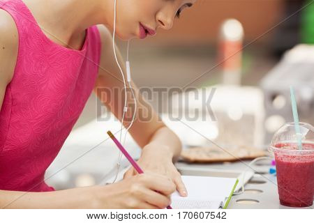 The girl in the pink dress with headphones composing