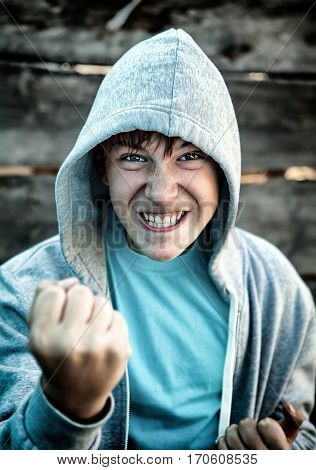 Toned Photo of Angry Teenager in Boxer Pose on the Wooden Background