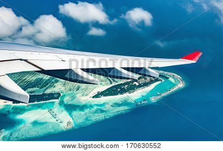 Airplane flying over blue sea and island beautiful view from window - Travel Concept