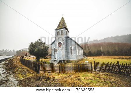 Antique style church in lush coastal landscape. Near Long Beach Washington USA. Foggy winter setting.