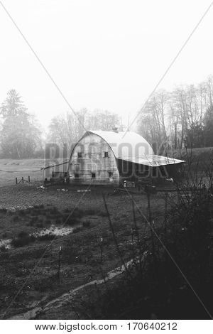Old barn building in countryside landscape near the Oregon coast. Winter day setting.Black and white photo.