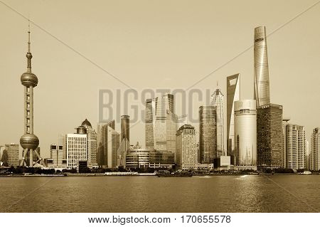 SHANGHAI CHINA - MARCH 25: Pudong district view from The Bund waterfront area on March 25 2016 in Shanghai China. Pudong is a district of Shanghai located east of the Huangpu River. Sepia toned photo