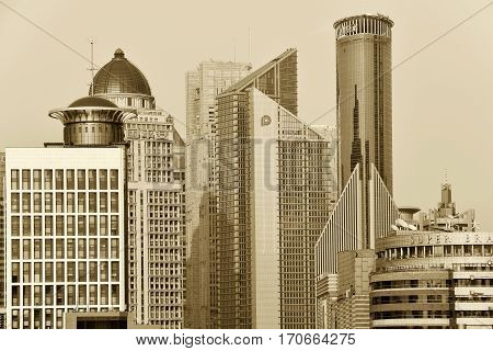 SHANGHAI CHINA - MARCH 25: Pudong district skyscrapers view from The Bund waterfront area on March 25 2016 in Shanghai China. Pudong is a district of Shanghai located east of the Huangpu River. Sepia toned photo