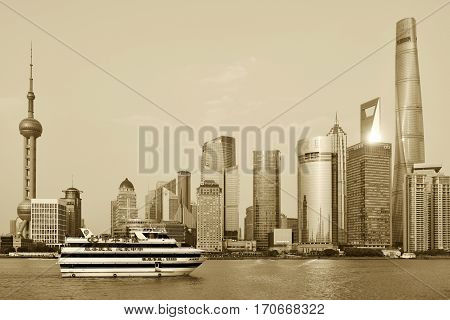 SHANGHAI CHINA - MARCH 25: Pudong district skyscrapers view from The Bund waterfront area on March 25 2016 in Shanghai China. Pudong is a district of Shanghai located east of the Huangpu River. Sepia toned photo