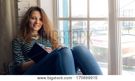 redhead girl notes her thinking on the window