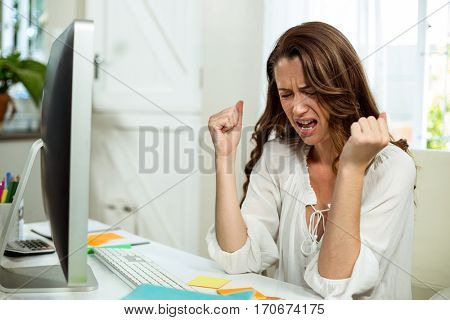 Irritated businesswoman in front of computer at desk in office